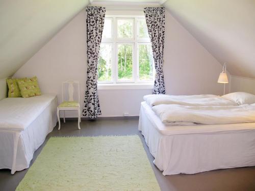 a attic bedroom with two beds and a window at Holiday Home Strøneneset by Interhome in Hagavik