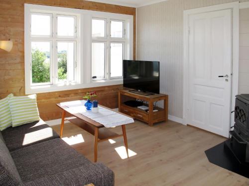 a living room with a couch and a tv and a table at Holiday Home Strøneneset by Interhome in Hagavik