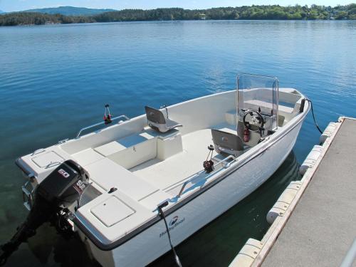 a white boat tied to a dock in the water at Holiday Home Strøneneset by Interhome in Hagavik