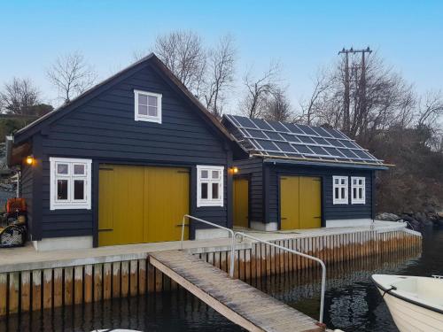 a blue and yellow house with solar panels on it at Holiday Home Strøneneset by Interhome in Hagavik