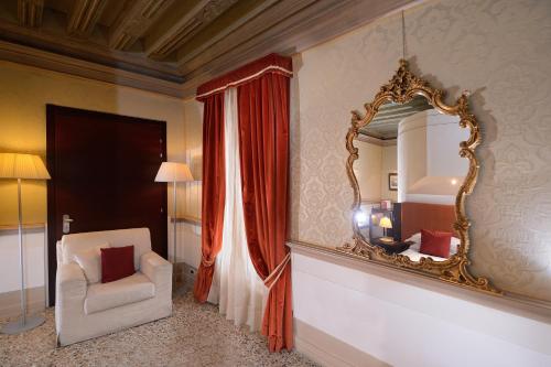 a room with a chair and a mirror on the wall at Ruzzini Palace Hotel in Venice