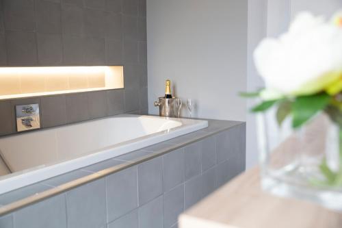 baño con lavabo y jarrón con flor en A Coque'Line, en Frasnes-lez-Anvaing