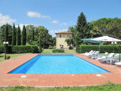a swimming pool in a yard with chairs and an umbrella at Villa Laura by Interhome in Agna