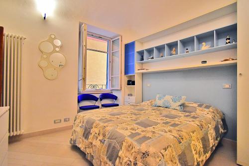 een slaapkamer met een bed en twee blauwe stoelen bij La Tana Del Poeta in Lerici