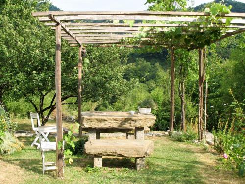 a wooden pergola with a picnic table and a bench at Holiday Home Casa Lienartova by Interhome in Grimacco