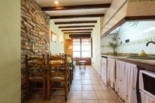 a kitchen with a table and a stone wall at Complejo Rural Turimaestrat in Sant Mateu