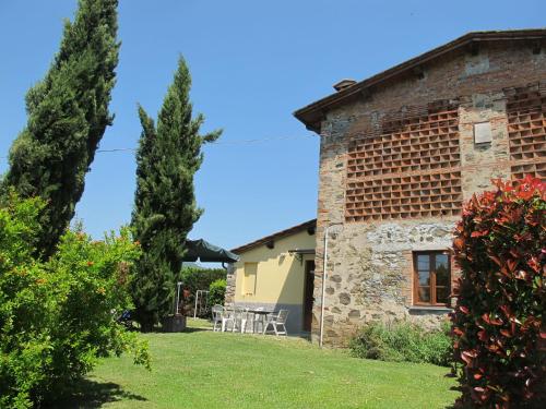Sant' AlessioにあるHoliday Home Giuseppe by Interhomeの庭にテーブルと椅子が備わるレンガ造りの建物