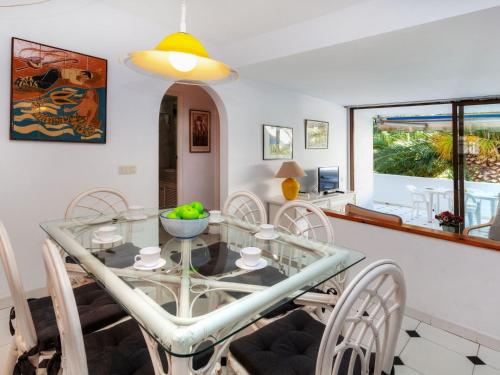 een eetkamer met een glazen tafel en stoelen bij Apartment Ducado Golf CII by Interhome in Pals