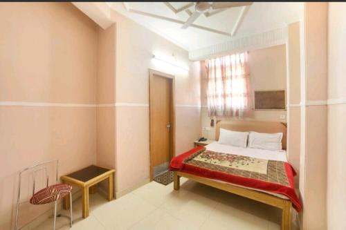a bedroom with a bed and a chair in it at Hotel Queen in Haridwār