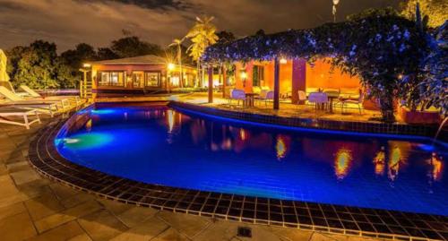 - une piscine en face d'une maison la nuit dans l'établissement VILLAS DO PRATAGY, à Maceió
