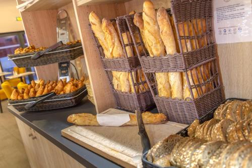 Un montón de panes en cestas sobre la encimera en SOWELL Family Riviera, en Saint-Raphaël