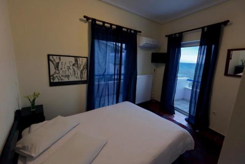 1 dormitorio con cama y ventana con vistas al océano en Star Hotel, en Nafpaktos