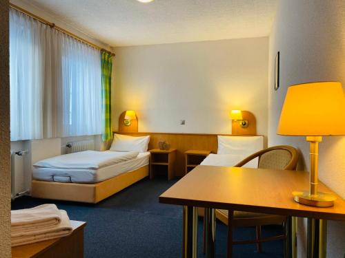 Pfarrweisach的住宿－祖姆高登阿德勒旅館，酒店客房设有两张床和一张桌子。