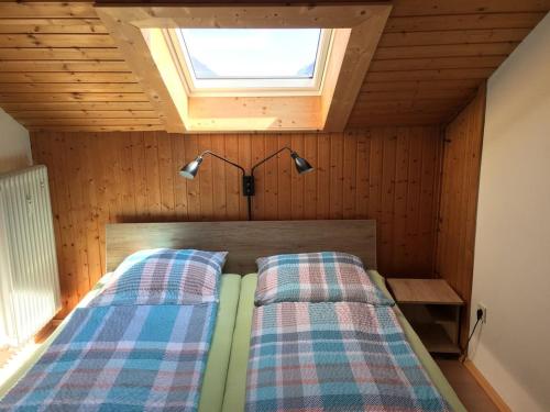 a bedroom with a bed with two lamps and a window at Ferienwohnung Alpenblick in Anger