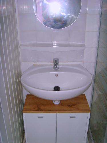 une salle de bain avec un lavabo blanc et un miroir dans l'établissement Les Aubettes, à Jumeaux