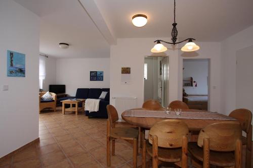 een eetkamer en een woonkamer met een tafel en stoelen bij Hellinghaus FeWo 4 Muschelsucher in Wyk auf Föhr