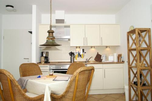 a kitchen with a table and chairs in a kitchen at Hellinghaus FeWo 3 Strandläufer in Wyk auf Föhr