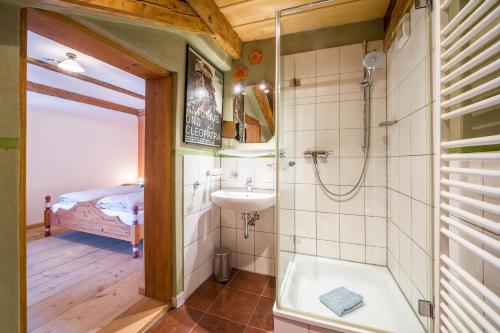 a bathroom with a shower and a sink and a tub at Ferienwohnung Gschwand in Unterammergau
