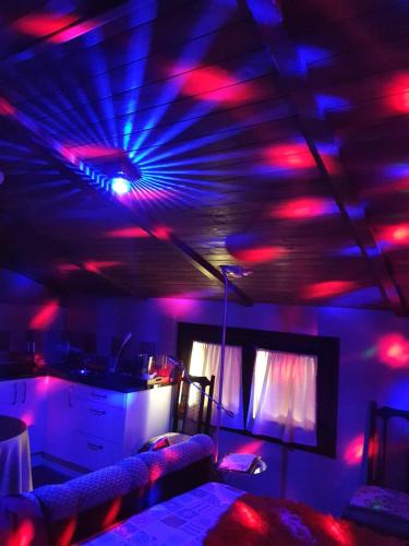 um quarto com luzes vermelhas e azuis no tecto em La Cabaña Romantica de Llano em Valência de Alcântara