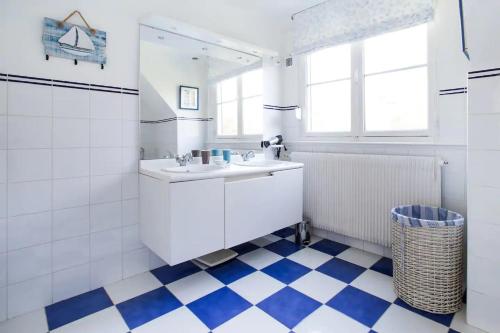 une salle de bain blanche avec un lavabo et une fenêtre dans l'établissement Les Glycines, à Croix