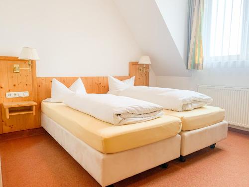 two beds sitting next to each other in a room at Landhotel Bauernschmitt in Pottenstein
