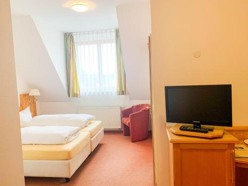 a hotel room with a bed and a television at Landhotel Bauernschmitt in Pottenstein