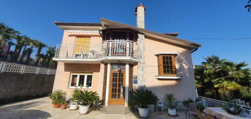 a house with a balcony and plants in front of it at Garni Stanger in Lovran