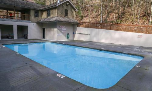 a large blue swimming pool in front of a house at Brentwood, Resort Pool, FREE Attraction tickets, Near Parkway, Hot Tub, Arcade Game, WIFI!!! in Pigeon Forge