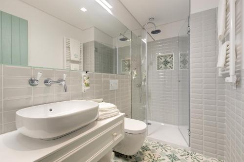 a white bathroom with a sink and a shower at 7 Bridges Estúdios- Porto-houses and suites in Porto