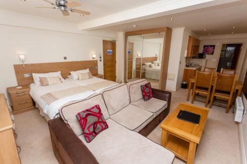 a hotel room with a bed and a couch at Porthole Suites in Saint Aubin