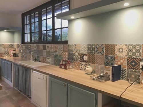 une cuisine avec un comptoir recouvert de carrelage. dans l'établissement Hibiscus House, à Carcassonne