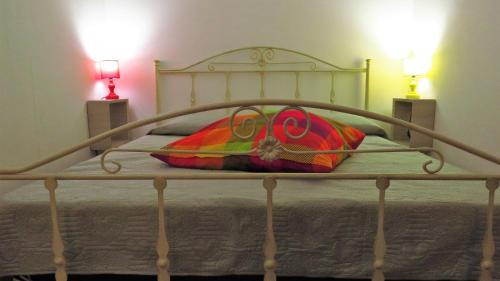 Una cama de metal con una almohada colorida. en Casita GioJa, en Gasponi