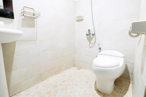 a bathroom with a toilet and a sink at Capital O 1666 Grand Pudjawan Hotel Near Kuta Beach in Kuta
