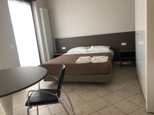 a bedroom with a bed and a table and chair at Monolocale Campo Romano in Schio