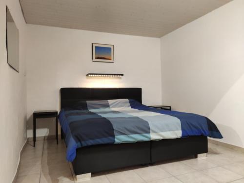 a bedroom with a bed with a blue and white comforter at Casa Blouberg in Gordevio