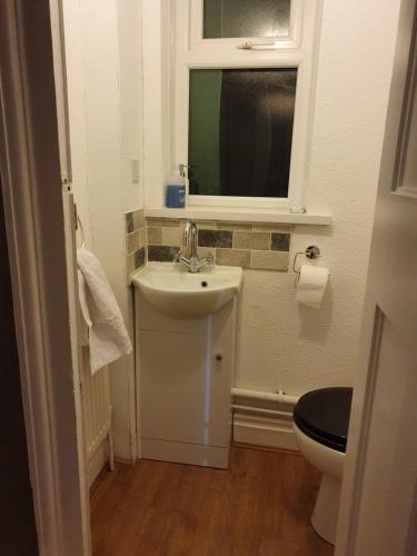 a bathroom with a sink and a toilet and a window at Central Location Preston 1 in Preston
