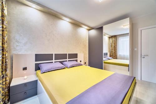 a bedroom with a large bed and a mirror at Апартамент S Apart in Varna City