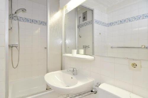 y baño blanco con lavabo y ducha. en Sylter-Besserburg-App-17, en Westerland