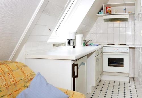cocina blanca con fregadero y fogones en Sylter-Besserburg-App-17, en Westerland