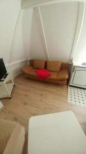 sala de estar con sofá y almohada roja en Sylter-Besserburg-App-17, en Westerland