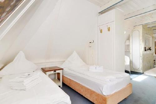 2 camas en una habitación con paredes blancas en Sylter-Besserburg-App-17, en Westerland