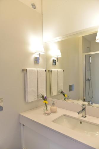 a white bathroom with a sink and a mirror at The Castle House in Lamego