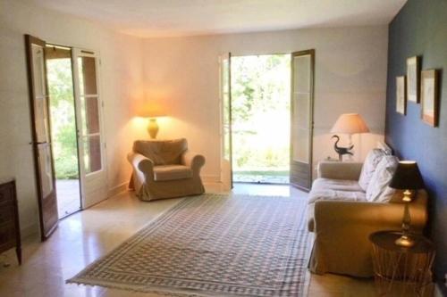 a living room with two chairs and a couch at Dans la bastide de Domme - piscine chauffée, parking privé in Domme