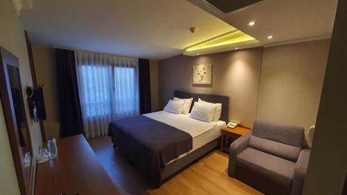a hotel room with a bed and a chair at Asur Hotel in Istanbul