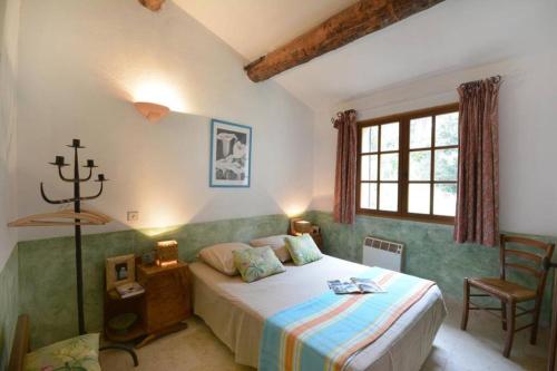 une chambre avec un lit, une chaise et une fenêtre dans l'établissement Villa Glycine -Mas de Joseph aux Baux de Provence, à Fontvieille