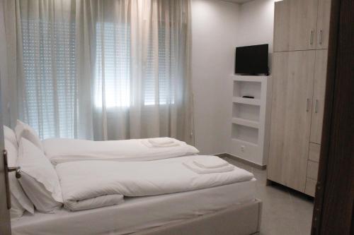 1 dormitorio blanco con 1 cama y TV en Apartment Ori, en Drama