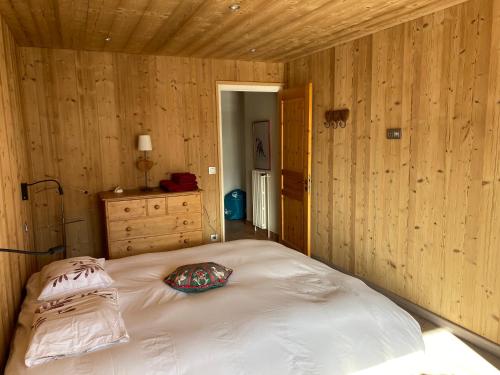 a bedroom with a white bed with wooden walls at Résidences DELAVAY LA FERME in Les Gets