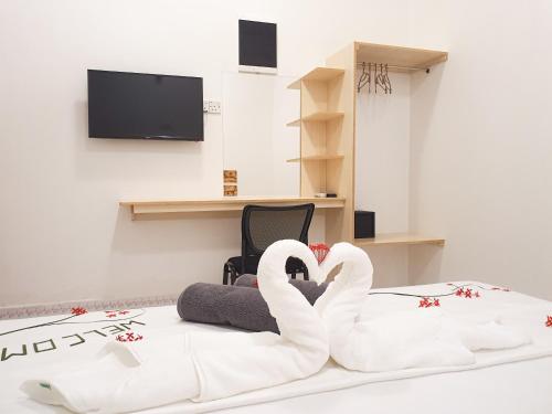 two white swans sitting on a bed in a room at Thoddoo Island Life in Thoddoo