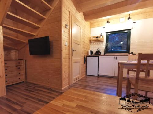 a kitchen with a table and a tv on a wall at Domki Wisła Dolina Partecznik in Wisła