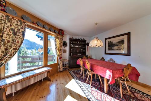 a dining room with a table and a large window at Chesa Pradash - Celerina in Celerina